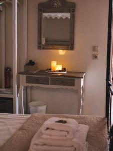 a bathroom with a bed with a mirror and a candle at Kleanthe in Halki