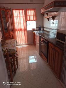 uma cozinha com um lavatório e um fogão forno superior em apartamento em Conil de la Frontera