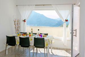 a dining room with a table with chairs and a window at Casa Renè in Tenno