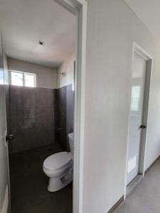 a bathroom with a white toilet and a window at HOST HOMESPACE in Tacloban