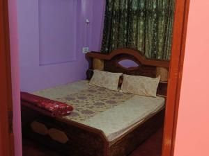 um pequeno quarto com uma cama com uma estrutura em madeira em Khushboo guesthouse em Srinagar