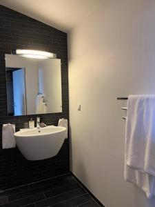 y baño con lavabo blanco y espejo. en DA Hotel Apartments en Gotemburgo