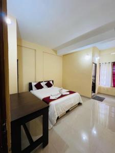 a bedroom with a bed and a table in it at Rivera Holiday Home in Vythiri