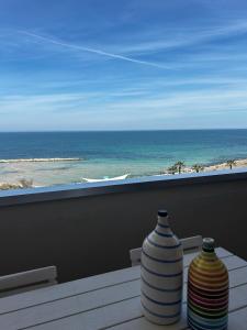 Dois vasos sentados numa mesa numa varanda com vista para o oceano em Front Beach Apartment - 3 Bedrooms em Bari