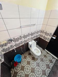 a bathroom with a toilet in a tiled wall at Rivera Holiday Home in Vythiri