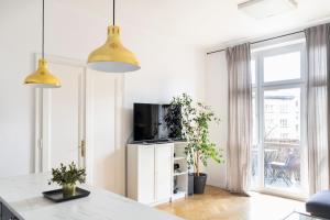 a living room with a tv and a large window at Kraków Apartments - Balcony, Workspace, Tram stop - by Rentujemy in Krakow