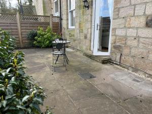 a chair sitting on a patio in front of a house at Micklefield Lodge in Leeds
