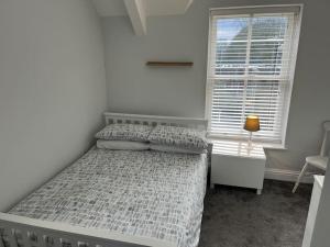 Micklefield Lodge في ليدز: سرير في غرفة مع نافذة وسرير سيد