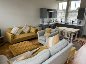 sala de estar con 2 sofás y cocina en Micklefield Lodge en Leeds