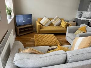 a living room with two couches and a tv at Micklefield Lodge in Leeds