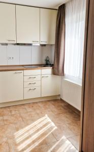 eine leere Küche mit weißen Schränken und einem Fenster in der Unterkunft Märchenwald Altenberg B&B Hotel in Odenthal