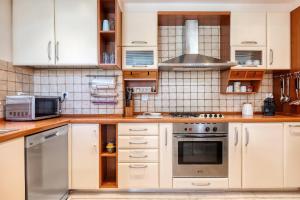 a kitchen with white cabinets and stainless steel appliances at Artistic Villa Luxury in Athens