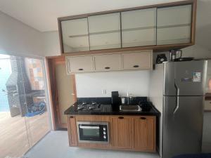 uma cozinha com um frigorífico e um fogão forno superior em Piranhasvillage03 em Piranhas