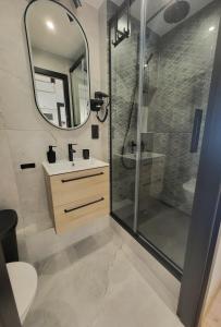 a bathroom with a shower and a sink and a mirror at Zaruskiego 2 in Ustka