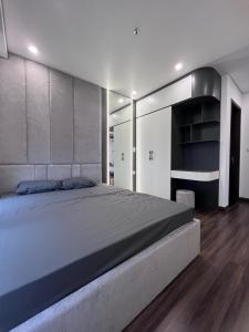 a bedroom with a large bed and wooden floors at 2702 HHG Apartment in Hai Phong