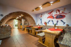un restaurante con mesas de madera y una pared con una pintura en Vinný sklep Krýsa en Kostelec