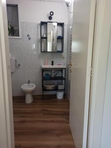 a bathroom with a sink and a toilet and a mirror at Petite Batty in Sori
