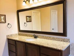 a bathroom with a sink and a large mirror at Luxurious 4br 3 baths office game room - 85 inch TV - Close to fishing boating and outdoors activities in Wylie