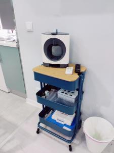 a microwave sitting on top of a cart in a kitchen at Riviera Beach A in Praia da Vitória