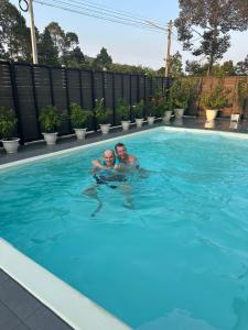 un hombre y un niño nadando en una piscina en Vergers de Nil les roses, 