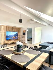 un salon avec une table et une télévision dans l'établissement Magnifique Appartement ,10 Min Orly Aéroport, à Paray-Vieille-Poste