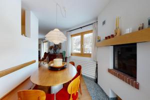 a dining room with a table and chairs and a tv at Apartment Cristolais in Samedan