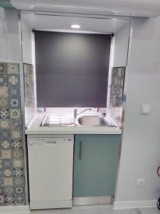 a small kitchen with a sink and a microwave at Riviera Beach A in Praia da Vitória