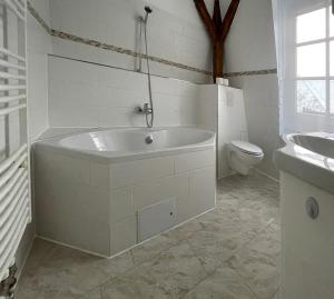 a white bathroom with a tub and a toilet at Apartments-Alt-Marzahn in Berlin