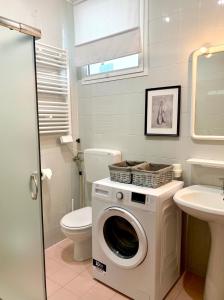 a washing machine in a bathroom with a toilet and a sink at Apartment Caorle de Lux swimming pool, parking, garden in Caorle