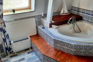 a bathroom with a large tub and a window at La Maraitière in Guînes +5 photos