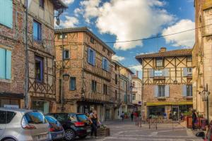 a street in an old town with cars parked at La maison de Marie, cosy et spacieuse - 3 chambres dont une climatisée in Châtillon-sur-Chalaronne