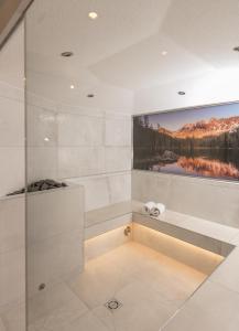 a bathroom with a large painting on the wall at Appartement & Suiten Hotel Glöcknerin in Obertauern