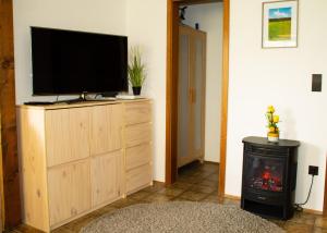 a living room with a television on a dresser with a fireplace at Ferienwohnung in Schönwald Schwarzwald in Schönwald