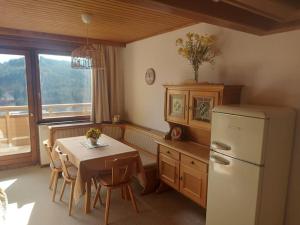 uma cozinha com uma mesa e um frigorífico branco em Sunny&Cozy - Maisonette Apartment in See Nähe em Feldkirchen in Kärnten