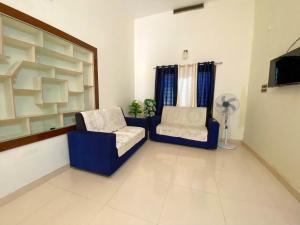 a living room with two chairs and a television at Day Dreams Homestay in Kalpetta