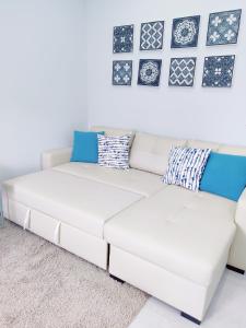 a white couch in a living room with pictures on the wall at Riviera Beach A in Praia da Vitória