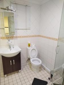 a bathroom with a toilet and a sink at Queen's Place in Johannesburg