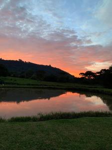 um pôr-do-sol sobre um lago num campo em Ausruhen Platz - Nova Petrópolis em Nova Petrópolis