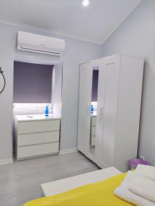 a white bedroom with a bed and a sink at Riviera Beach A in Praia da Vitória