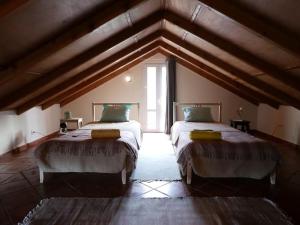 a large room with two beds in a attic at GuestReady - Casa do Bisbis in Lanceiros