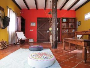 Lanceiros的住宿－GuestReady - Casa do Bisbis，一间红色墙壁的房间,一张桌子上有一个蛋糕
