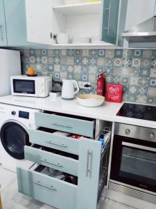 a kitchen with a washing machine and a microwave at Riviera Beach A in Praia da Vitória