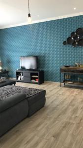 a living room with a bed and a tv at Maison a partager avec l'hôte in Digne-les-Bains