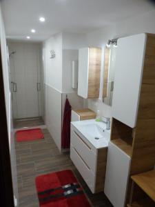 a bathroom with a white sink and a shower at Ferienwohnung Eifelrose in Vorpochten