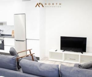 a living room with a couch and a tv at Apartamento Roncudo 4º planta in A Coruña