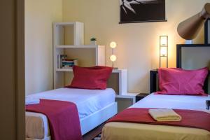 una camera con due letti con cuscini rossi di GuestReady - Hikers Haven a Faial