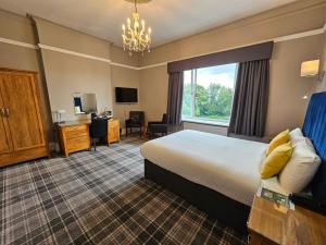 Habitación de hotel con cama y escritorio en Burnley West Higher Trapp Hotel en Padiham