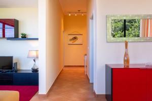a living room with a red cabinet and a hallway at GuestReady - Hikers Haven in Faial