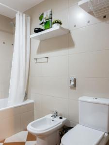 een witte badkamer met een toilet en een wastafel bij GuestReady - A sunny delight in Funchal in Funchal