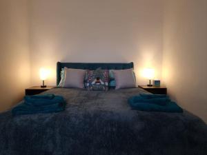 - une chambre avec un grand lit et deux lampes dans l'établissement Gorgeous Edwardian Terrace in Old Trafford, à Manchester